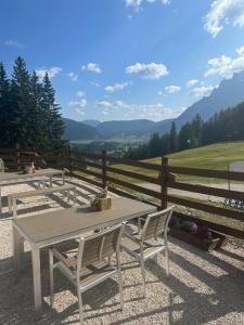 a picnic table and chairs with a view of mountains at Waldhaus Talblick in Biberwier