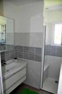 een badkamer met een bad, een wastafel en een douche bij Maison Roche Blanche in Port Blanc +3 foto's