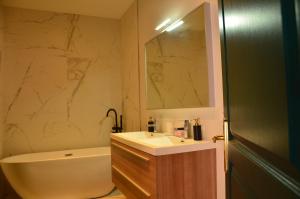 a bathroom with a sink and a tub and a mirror at Digue in Wimereux +61 photos
