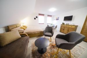 1 dormitorio con cama, sofá y sillas en Apartmán 1 Fklidu, en Znojmo