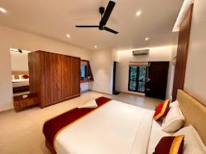 a bedroom with a bed and a ceiling fan at Cliffotel Kerala in Chithragiri