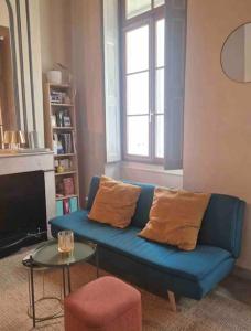 a blue couch in a living room with a window at Appartement plein centre-ville in Nîmes