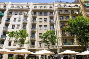 un grande edificio bianco con ombrelloni di fronte di Gaudi Sagrada Familia a Barcellona