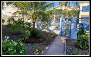 a fence with a palm tree in front of a house at Imagine-Bohol in Panglao