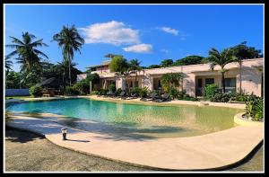 una grande piscina di fronte a una casa di Imagine-Bohol a Panglao