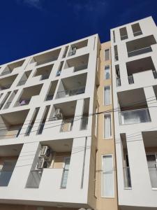 un alto edificio blanco con ventanas y un cielo azul en Go Exchange, Block F, Apt. 11, en St Paul's Bay