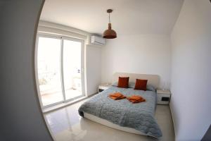 Un dormitorio con una cama y una ventana grande. en Go Exchange, Block F, Apt. 11, en St Paul's Bay