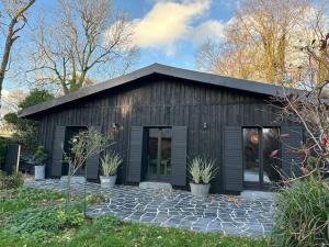 a black building with potted plants in front of it at Chalet de l'Ailly in Varengeville-sur-Mer