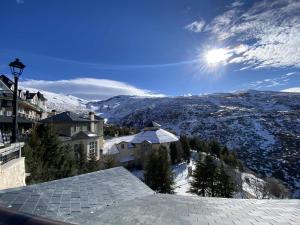 - une vue depuis le toit d'une maison dans la neige dans l'établissement Apartamento con garaje Plaza de Andalucía, à Sierra Nevada