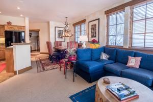 a living room with a blue couch and a table at Westridge Condo 27 - Cozy Condo Walk to Bald Mt and Downtown Ketchum in Ketchum