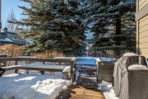 une terrasse en bois avec deux bancs dans la neige dans l'établissement Dollar Meadows Condo 1382 - Cozy & Sun Valley Resort Amenities Included, à Sun Valley