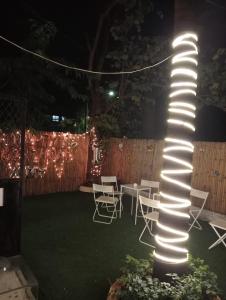 een verlichte paal met stoelen en 's nachts een tafel bij Hostell One - A complete backpacker & Coworking Hub in Pune