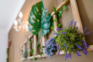 un estante con flores púrpuras y plantas. en Villa 10 Luxe by Lirios Village Marbella en Marbella