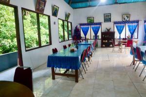 a dining room with blue tables and chairs at Tangkoko Homestay in Rinondoran