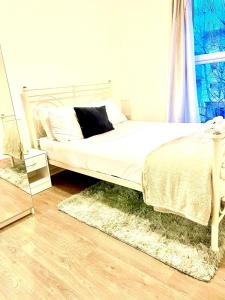 a bedroom with a bed with white sheets and a mirror at Peaceful Impeccable 2-Bed Apartment in Hatfield in Hatfield