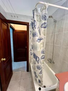 La salle de bains est pourvue d'un rideau de douche bleu et blanc. dans l'établissement Parada do Camiño de Santiago, à Betanzos