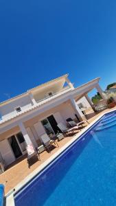 a house with a swimming pool next to a building at Villa Carpe Diem (Seize the day) in Carvoeiro