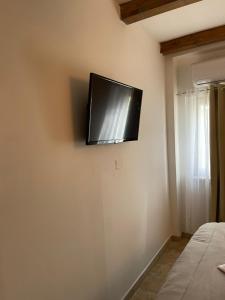 TV de pantalla plana en la pared de un dormitorio en Trullo Santa Lucia, en Cisternino