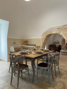 cocina con mesa de madera y algunas sillas en Trullo Santa Lucia, en Cisternino