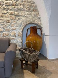 un jarrón y una cesta en una mesa junto a una pared de piedra en Trullo Santa Lucia, en Cisternino