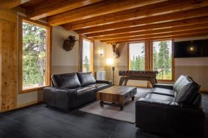 sala de estar con muebles de cuero y mesa de billar en Red Cariboo Resort, en Anahim Lake