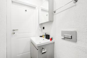 a white bathroom with a sink and a mirror at Central Furnished Studio 5 min to Coast in Fatih in Istanbul