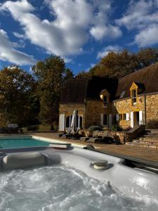 a house with a swimming pool in front of a house at Luxury Chateau w. pool & hot tub in Dordogne in Cazenac