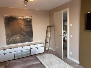 een slaapkamer met een witte dressoir met een schilderij aan de muur bij Ferienwohnung "Auszeit Im alten Weinberg" in Leiwen