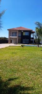una casa grande con un campo de hierba delante de ella en Executive 4 bedroom house with 4 beds ., en Lusaka