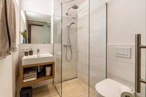 a bathroom with a glass shower and a sink at Ferienwohnung Sonnenhalde in Moos