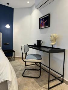 a desk with a chair and a bust on a wall at Misk Villa - Boutique Hotel & Spa in Sidi Bou Saïd