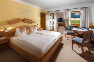 a bedroom with a large bed and a living room at Bindenhäusl - Ramsau in Ramsau