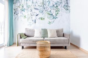 uma sala de estar com um sofá e um mural de parede em Apartamenty Sea Colors - Nowoczesne i Komfortowe Apartamenty w Jastrzębiej Górze em Jastrzebia Gora