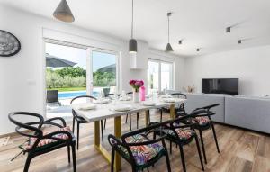 - une salle à manger et un salon avec une table et des chaises dans l'établissement Modern villa Casa Storija with pool in Novigrad, à Bužinija