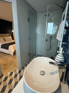 a bathroom with a toilet and a shower and a bed at Misk Villa - Boutique Hotel & Spa in Sidi Bou Saïd