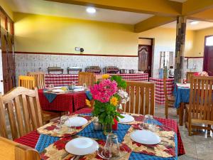 um restaurante com uma mesa com flores em MACHAGE TOURS AND SAFARIS HOTEL em Karatu