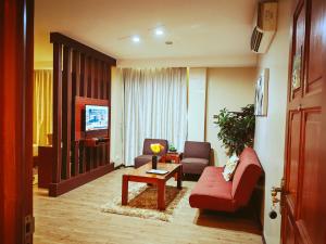 sala de estar con sofá rojo y TV en Great Wall Hotel en Dar es Salaam