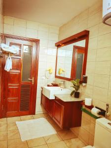y baño con lavabo y espejo. en Great Wall Hotel, en Dar es Salaam