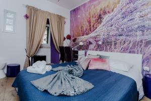 a bedroom with a blue bed with a purple wall at Guesthouse Mimbelli in Orebić