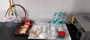 ガンディーナガルにあるVIAAN Penthouse 1 BHK with terraceの水のボトルとスプーンと皿が置かれたカウンター +2枚の写真