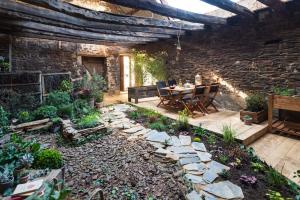 un patio con tavolo e sedie in un giardino di Gîte bien être et écologique Le Jardin intérieur a Saint-Congard