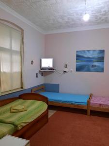 a room with two beds and a tv on the wall at HI Youth and Business Apartments in Belgrade