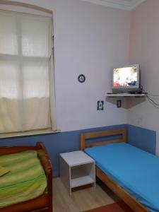 a bedroom with two beds and a tv on the wall at HI Youth and Business Apartments in Belgrade