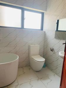 a white bathroom with a toilet and a sink at Executive 4 bedroom house with 4 beds . in Lusaka