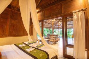 een slaapkamer met 2 bedden in een kamer bij Bale D'Uma Joglo in Ubud