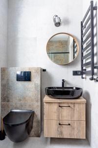 baño con lavabo negro y espejo en Apartamenty Sea Colors - Nowoczesne i Komfortowe Apartamenty w Jastrzębiej Górze, en Jastrzębia Góra