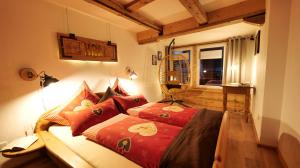 a bedroom with a bed with red sheets and a window at Rosi´s Häusle Schwarzwald / Terasse mit Garten in Winzeln