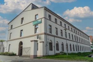 een groot wit gebouw met een bord erop bij Hostel Krośnieńska 12 in Zielona Góra