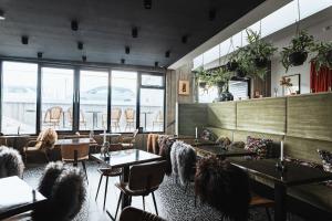 un ristorante con tavoli, sedie e finestre di Hotel Leifur Eiriksson a Reykjavik