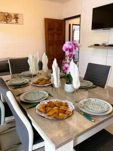einen Tisch mit Teller mit Lebensmitteln und Blumen darauf in der Unterkunft Charme du Nord 1 in Sainte-Clotilde